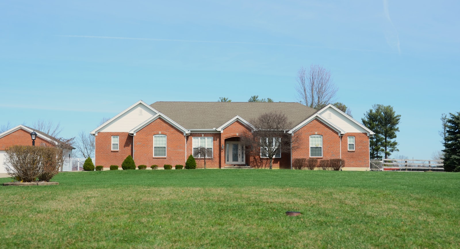 Brick front home in north Dallas with a freshly mowed and edged green lawn.